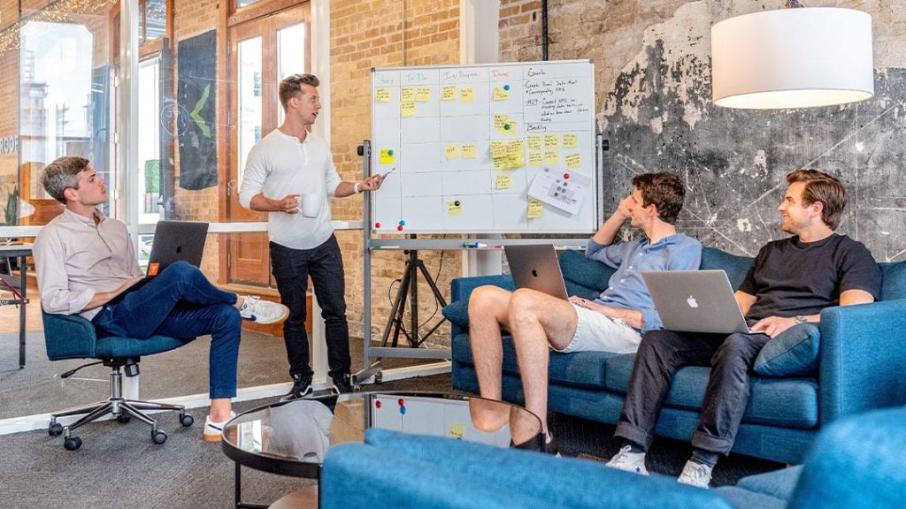 Entrepreneur team brainstorming B2B marketing tactics on a whiteboard