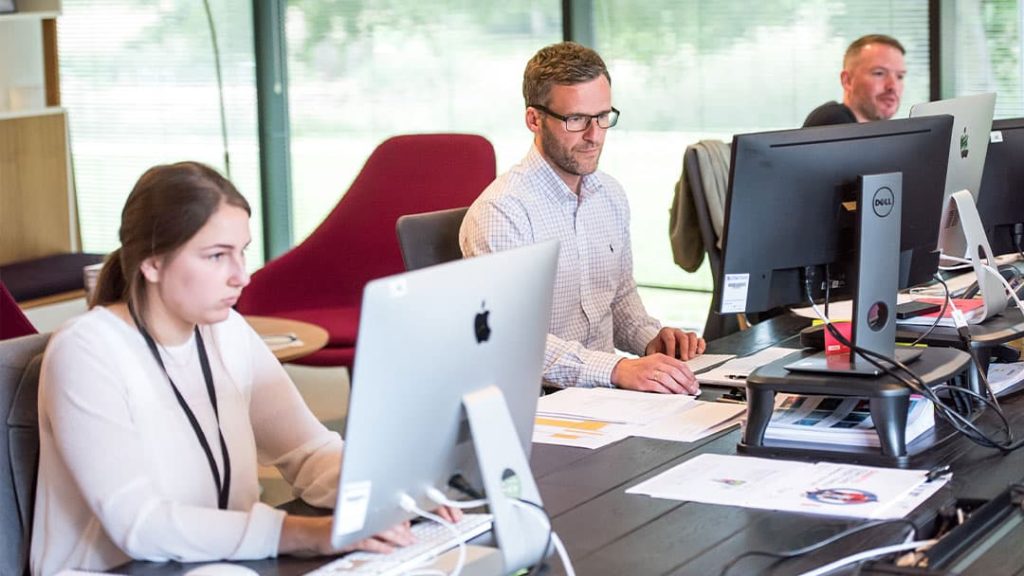 Call center employees busy at work behind their computers